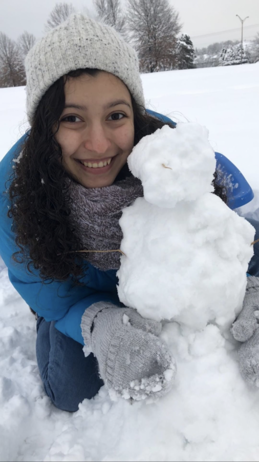 Junior Ashley Honey takes to the drifts to build a snowman