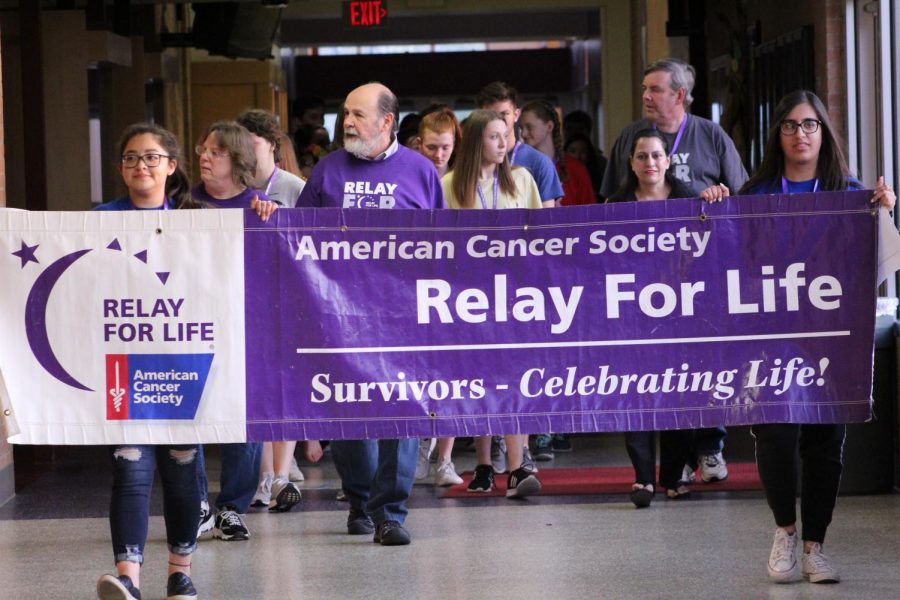 The+participants+of+Relay+for+Life+carrying+the+banner+through+the+halls++during+the+Survivor+Lap.
