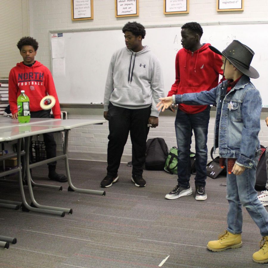 A cowboy trick or treater participates in ring toss in the Black Student Union room.