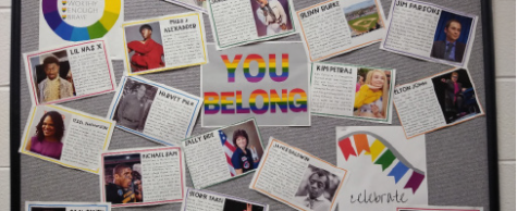 A bulletin board with photos and descriptions of LGBTQ+ people and their acheivments in their life. The display is located near Ms. Bloomers art class. Photo by Liz O’hara.